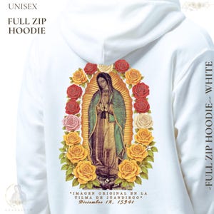 May include: White unisex full zip hoodie featuring a religious image of a woman surrounded by roses. The text on the back reads "IMAGEN ORIGINAL EN LA TILMA DE JUANDIEGO" and "Diciembre 12, 15946". The sleeve reads "-FULL ZIP HOODIE-- WHITE".