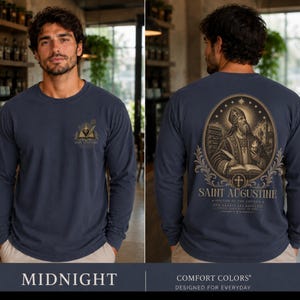 Könnte beinhalten: Ein marineblaues Langarmshirt mit einer kleinen Grafik auf der Brust und einer großen ovalen Illustration auf dem Rücken. Das Rückendesign zeigt den heiligen Augustinus mit Buch und Herz sowie den Text Saint Augustine, Doctor of the Church.