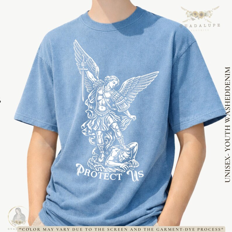 May include: Light blue unisex youth washed denim t-shirt with a white graphic of an angel with a sword, standing over a defeated figure. The text "PROTECT US" is below the graphic. The shirt has short sleeves.