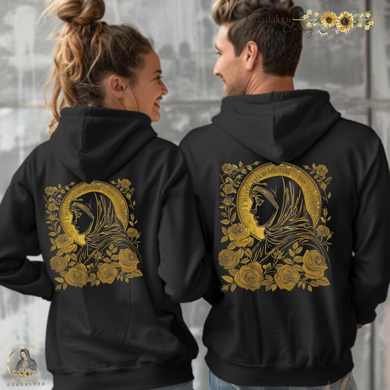 May include: Black hooded sweatshirts featuring a gold illustration of a religious figure surrounded by roses. The design is on the back of the sweatshirts. The sweatshirts are worn by two people.