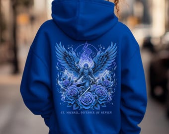 May include: A blue hoodie with a graphic of Saint Michael, the Archangel, with a sword and wings. The graphic is surrounded by blue roses and flames. The text "ST. MICHAEL, DEFENDER OF HEAVEN" is printed below the graphic. The hoodie is unisex and royal blue.