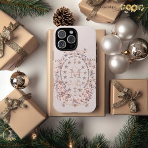 May include: White iPhone case with a floral design and the text "Pray for Us Who Have Recourse to Your Mother." The design features a gold Virgin Mary icon and stars.