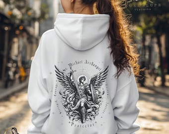May include: White unisex hoodie with a black and white graphic print of Saint Michael the Archangel. The graphic features a winged angel holding a sword and shield. The text around the graphic reads "St. Michael Archangel", "Guidance, Justice, Strength, Courage", and "Protector".