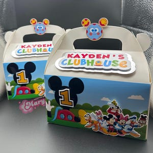 May include: Two white gable boxes with Mickey Mouse Clubhouse theme. Each box features a Mickey Mouse silhouette, the number 1, and the text "KAYDEN'S CLUBHOUSE". The boxes are decorated with cartoon characters and a blue and yellow character on top.