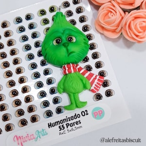 May include: Green Grinch character made of polymer clay with a red and white striped scarf. The Grinch is 5.5 cm wide and 6.5 cm tall. The image also shows a sheet of 55 pairs of plastic doll eyes in various colours.
