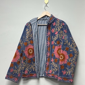 May include: A white ceramic mug with a black handle and the text "But First, Coffee" in a black, bold font. The mug is on a white surface.