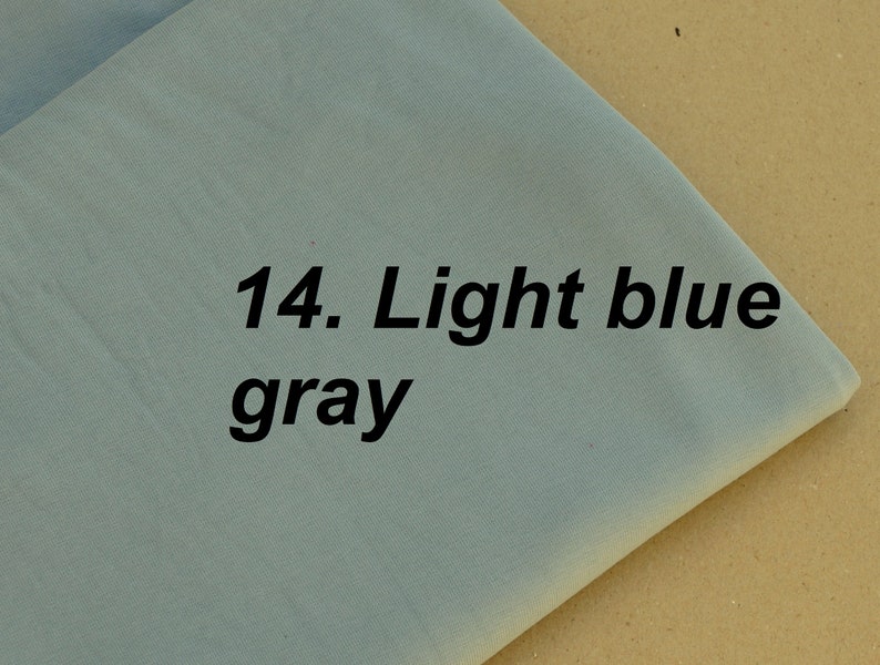 Puede incluir: Una muestra de tela gris azul claro con el texto "14. Gris azul claro" impreso en ella.