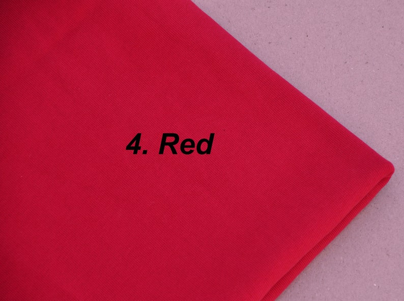 Puede incluir: Primer plano de una muestra de tela de color rojo brillante con el texto "4. Red" impreso en ella.