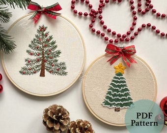 May include: Two embroidery hoops with Christmas tree designs. The first hoop features a green tree with red berries and a brown trunk. The second hoop features a green tree with white beads and a yellow star on top. Both hoops have red and green plaid bows. The text "PDF Pattern" is visible in the bottom right corner.