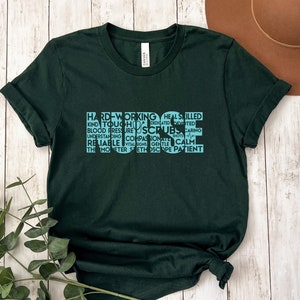 May include: A dark green t-shirt with a light blue design that reads "HARD WORKING HEAL SKILLED KIND TOUCH DEDICATED DEVOTED BLOOD PRESSURE SCRUBS CARING UNDERSTANDING COMPASSION RELIABLE VITAL SIGNS GENTLE CALM THE MONITOR STETHOSCOPE PATIENT"