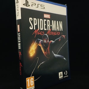 May include: A PlayStation 5 game case with a black background and a red and black image of Spider-Man Miles Morales. The text "MARVEL SPIDER-MAN MILES MORALES" is written in white on the case. The game is rated 16+ by PEGI.