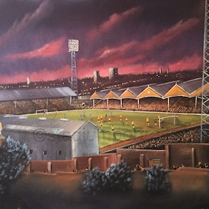 May include: A painting of a football stadium at night with a pink and purple sky. The stadium is lit up with floodlights and there are people in the stands. The pitch is green and there are players on the pitch.