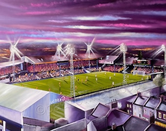 May include: A painting of a football stadium at night with floodlights illuminating the field. The stands are full of fans and the sky is a vibrant purple with pink clouds. The stadium is surrounded by houses and trees.