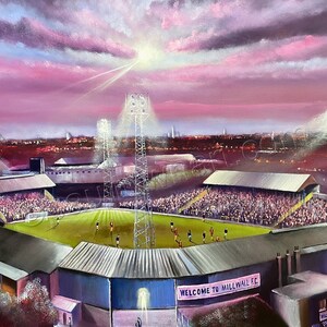 Puede incluir: Una pintura de un estadio de fútbol por la noche con focos que iluminan el campo y las gradas. El cielo es de un rosa y morado vibrante con nubes. El letrero en el estadio dice "Bienvenido al Millwall FC".