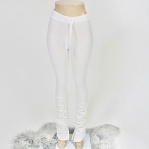 May include: White pants with a drawstring waist and a stacked leg design.