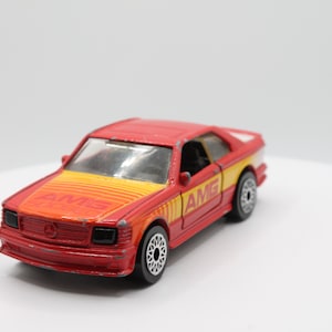 May include: Red and yellow toy car with "AMG" printed on the side.