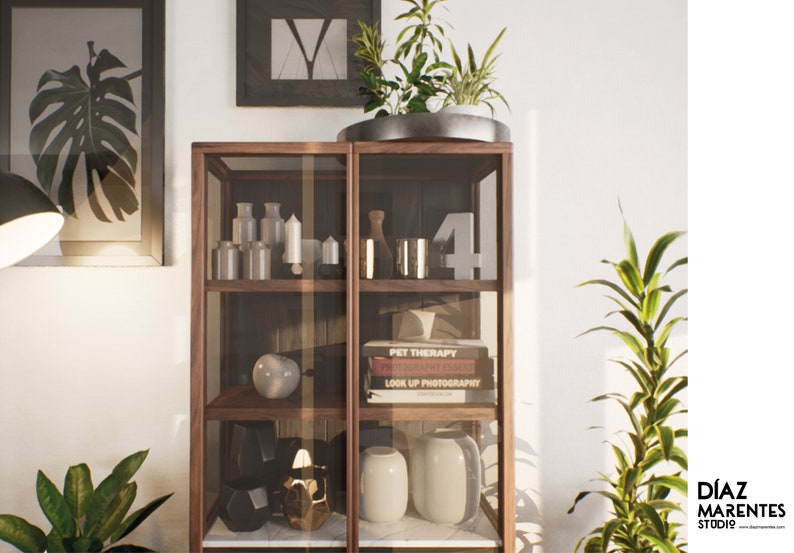 K&ouml;nnte beinhalten: Ein Holzvitrine mit Glasb&ouml;den, die verschiedene Dekorationsartikel zeigt, darunter Kerzen, Vasen, B&uuml;cher und eine Keramik-Kugel. Die Vitrine steht vor einer wei&szlig;en Wand mit einem gerahmten Druck und einer Topfpflanze.