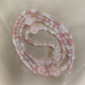 May include: A pink and white beaded necklace with rose quartz beads and a few larger rose quartz stones.