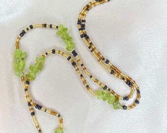 May include: A multi-strand beaded necklace with green gemstone beads and black and gold beads.