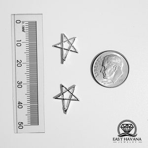 May include: Two silver star-shaped pendants with a pentagram design. A ruler shows measurements in millimeters, and a dime is included for size comparison. The pendants are on a white surface. The East Havana Jewelry logo is in the bottom right corner.