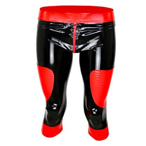 Pode incluir: Leggings de látex pretas e vermelhas com cós e joelheiras vermelhas. As leggings têm um zíper frontal e vão até o joelho. O material brilhante reflete a luz, criando uma aparência brilhante.
