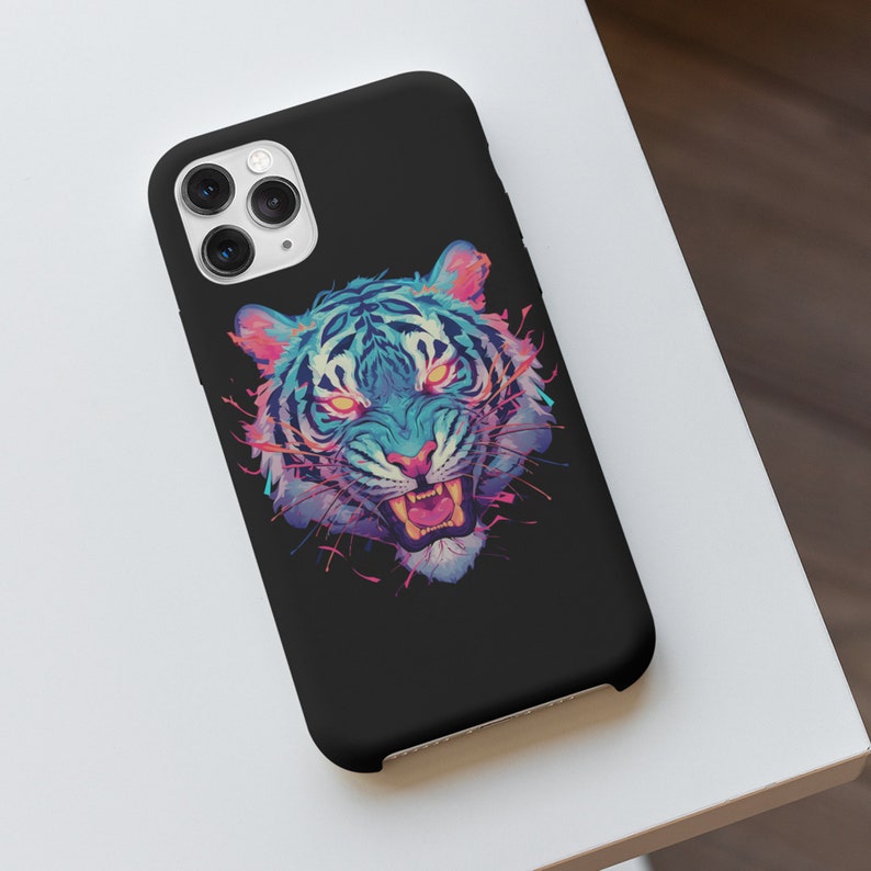 K&ouml;nnte beinhalten: Schwarze Handyh&uuml;lle mit einer bunten Tiger-Illustration. Der Tiger hat blaue, rosa und lila Akzente und ist mit offenem Maul im Br&uuml;llen dargestellt.