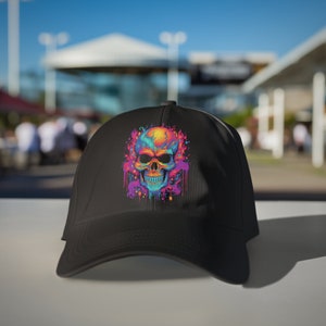 May include: Black baseball cap featuring a colourful skull graphic. The skull is surrounded by a design of pink, blue and purple paint splatters.