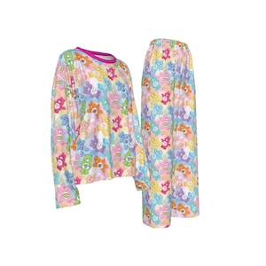 K&ouml;nnte beinhalten: Ein zweiteiliger Pyjama-Set mit einem farbenfrohen Care Bears-Muster. Das lang&auml;rmlige Oberteil hat einen rosa Besatz am Halsausschnitt. Die passende Hose ist weit geschnitten. Das Set ist aus einem weichen, leichten Stoff gefertigt.