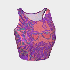 May include: A vibrant crop top featuring a psychedelic design. The top showcases a portrait of a bearded person wearing sunglasses with a star on one lens. The color palette includes shades of pink, purple, and green, creating a bold and artistic look.