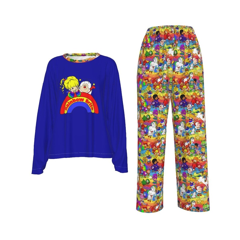 May include: A two-piece pajama set featuring a long-sleeved blue top and patterned pants. The top has a Rainbow Brite graphic on the front. The pants are covered in a colorful cartoon pattern. The pajamas are made of a soft material.