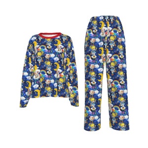 May include: Blue pajamas with a long-sleeved top and pants. The pajamas feature a repeating pattern of a girl with a rainbow and stars on a dark blue background.