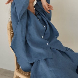 Pu&ograve; includere: Un set di camicia e gonna in lino blu. La camicia ha un colletto e maniche lunghe. La gonna &egrave; a trapezio e arriva alle ginocchia.
