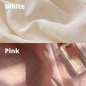 Pu&ograve; includere: Due campioni di tessuto, uno bianco e uno rosa, con un flacone di profumo in vetro trasparente sul campione rosa. Il flacone ha un'etichetta che dice "LOEWE 001 WOMAN".