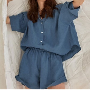 Pu&ograve; includere: Un pigiama in lino blu con una camicia con colletto e pantaloncini. La camicia ha una chiusura con bottoni sul davanti e i pantaloncini hanno una cintura elastica.