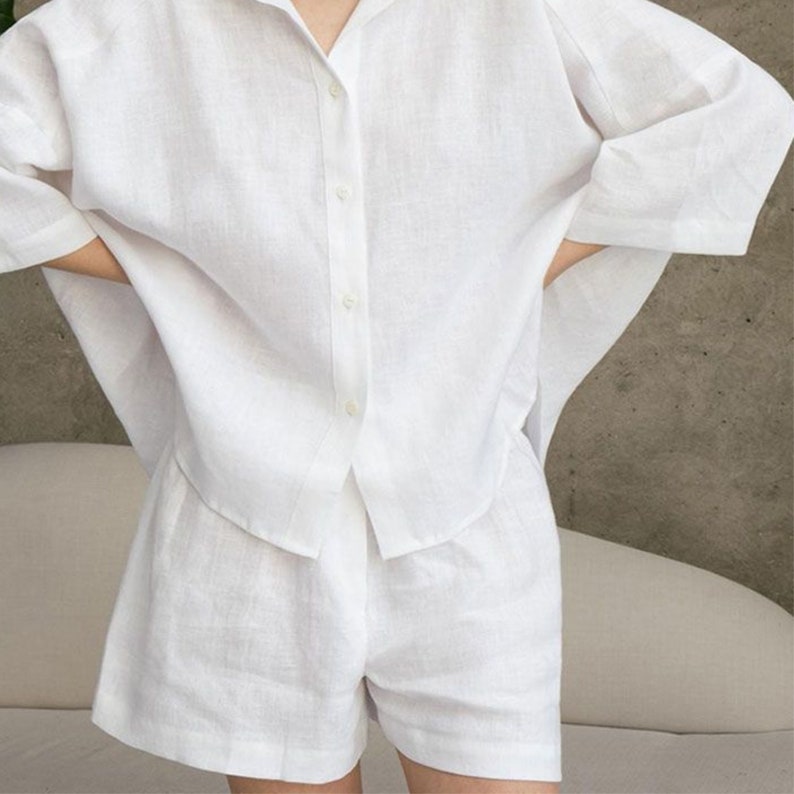 Pu&ograve; includere: Un set di camicia e pantaloncini in lino bianco. La camicia ha una vestibilit&agrave; rilassata e i pantaloncini hanno una vita alta.