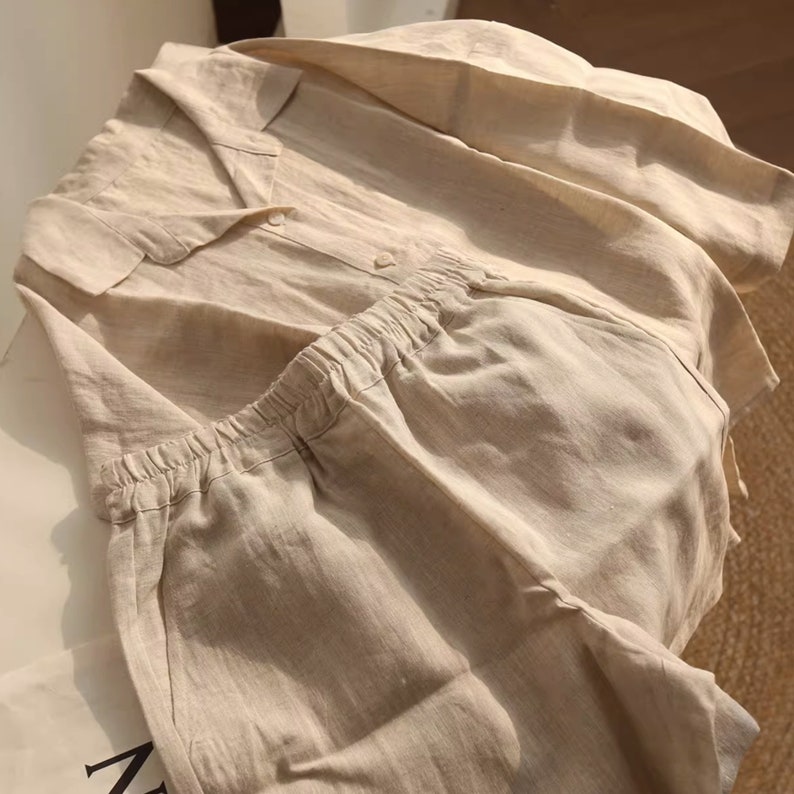 Pu&ograve; includere: Un pigiama in lino beige con camicia a collo e pantaloncini. La camicia ha una chiusura con bottoni e i pantaloncini hanno una cintura elastica.