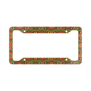 May include: A license plate frame with a colorful geometric pattern in shades of red, yellow, green, and black. The frame is made of metal and has holes for attaching to a license plate.