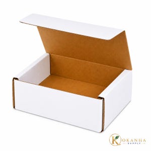 May include: A rectangular cardboard shipping box with a white exterior and a natural brown interior. The box features a hinged lid that is partially open, revealing the inner structure. The logo KOKANHA SUPPLY is visible in the bottom right corner.