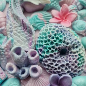 May include: A collection of pastel-colored, handmade, polymer clay sea-themed decorations. The decorations include starfish, seashells, coral, and flowers.