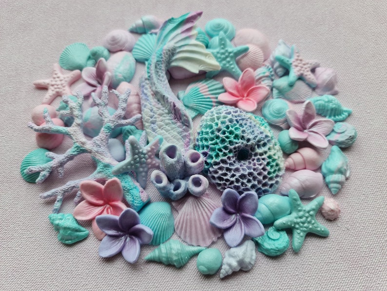 May include: A collection of pastel-colored seashells, starfish, coral, and flowers. The seashells are in various shapes and sizes, and the flowers are in shades of pink and purple. The coral is a light pink color and the starfish are a light blue color.