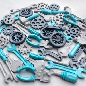 May include: A collection of blue and silver metal tools and gears. The tools include wrenches, screwdrivers, pliers, and a hammer. The gears are various sizes and shapes.