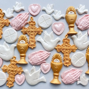 Può includere: Assortimento di decorazioni per torte a tema religioso di colore bianco e oro. Le decorazioni includono colombe, croci, calici, mani in preghiera e ostie.