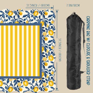 May include: A beach blanket with a yellow and white striped center, a blue border, and a white background with a lemon and leaf pattern. The blanket is 31.5 inches (80cm) square. A black carrying bag with a shoulder strap is included.