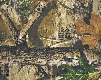 May include: Camouflage fabric with a Realtree Edge pattern. The design features a mix of brown, tan, and green hues, with detailed depictions of tree branches, leaves, and bark. The Realtree Edge logo is visible.