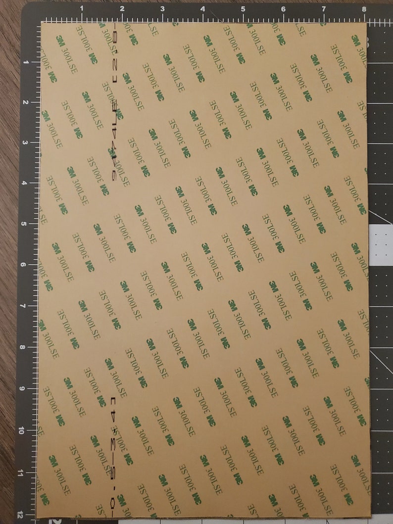 May include: A sheet of brown adhesive tape with a repeating pattern of green text that reads "3M 300LSE".