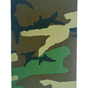 May include: Camouflage fabric with a green, brown, and black pattern. The fabric has a woven texture.