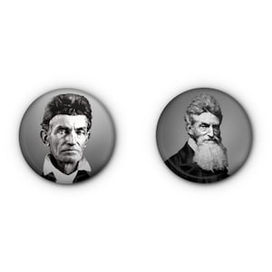 May include: Two round, grayscale buttons featuring portraits of John Brown. One button shows a close-up of his face, and the other depicts him with a long, white beard. The buttons have a gradient gray background.