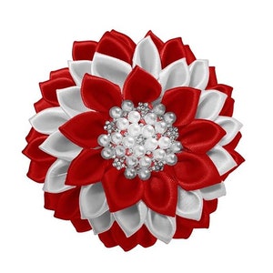 May include: A handcrafted, flower-shaped hair accessory. The petals are alternating red and white satin. The center features a cluster of faux pearls and rhinestones. This decorative piece is suitable for various occasions.