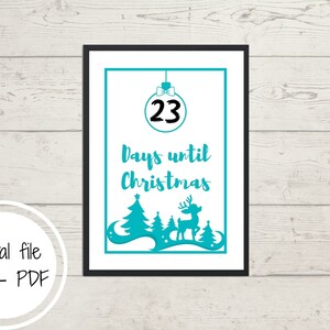 May include: A framed print with a teal design counting down to Christmas. The design includes a Christmas ornament with the number 23, the text "Days until Christmas", and a silhouette of trees and a reindeer. The text "Digital file only - PDF" is also included.