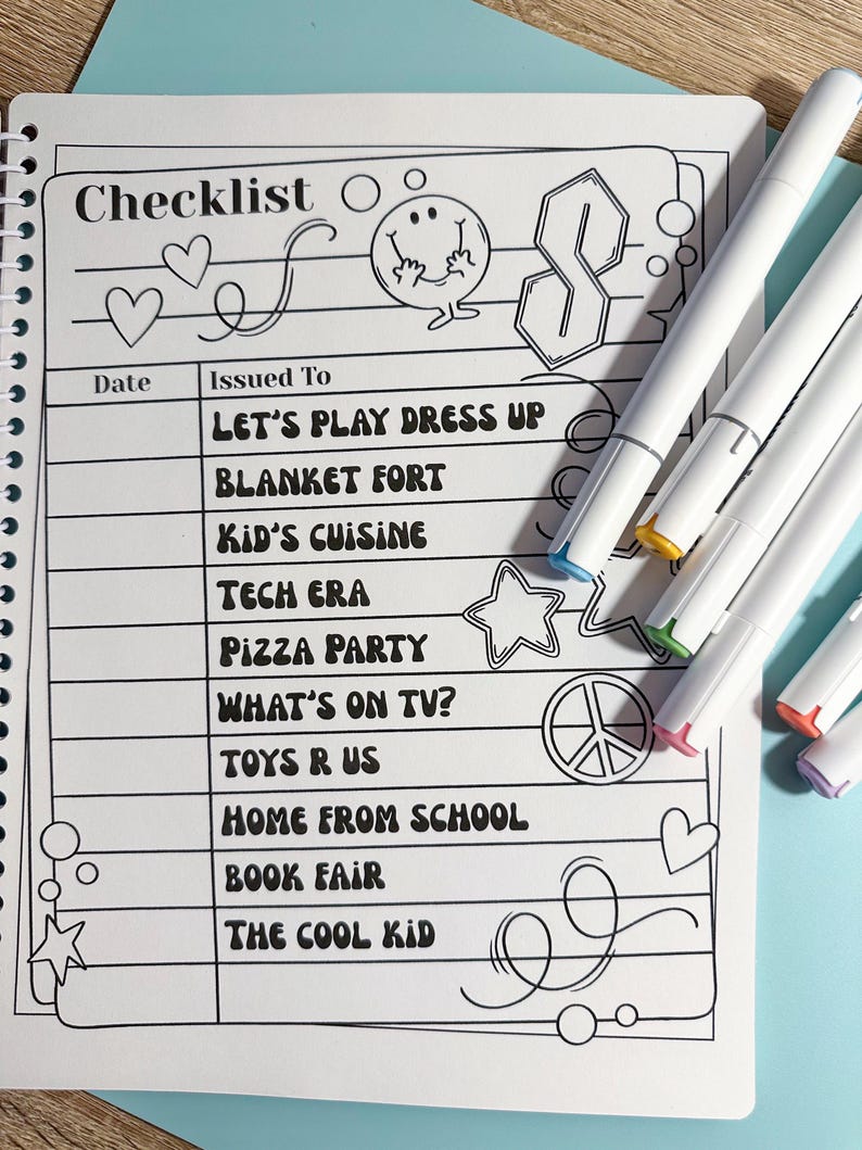 Puede incluir: Un cuaderno de lista de verificaci&oacute;n con espiral con un dise&ntilde;o en blanco y negro. La lista de verificaci&oacute;n incluye actividades como "Let's Play Dress Up" y "Pizza Party". Varios marcadores blancos con puntas de colores est&aacute;n junto al cuaderno.